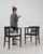This pair of armchairs carries genuine presence, its black wood frame, caned back, dark upholstered seat immediately...