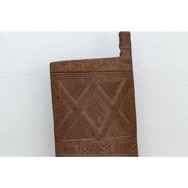 From the Voltaic-speaking regions spanning Burkina Faso and Mali, this single-plank shutter is carved with a dense waffle-...
