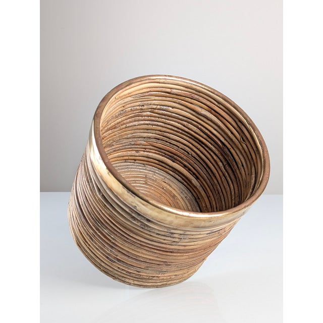 A cylindrical planter produced in the 1970s, showcasing the distinctive Italian "pencil reed" rattan technique. The...