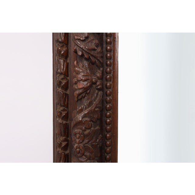 A magnificent French mirror featuring a richly hand‑carved oak frame with deep relief detailing of foliate and scroll...