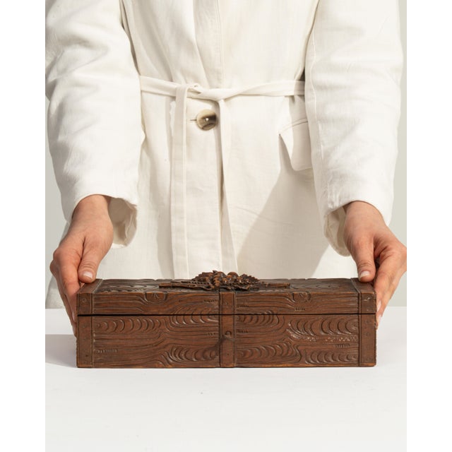 This early 20th century Black Forest box from Switzerland is finished in brown, worked in wood. Its design carries the...