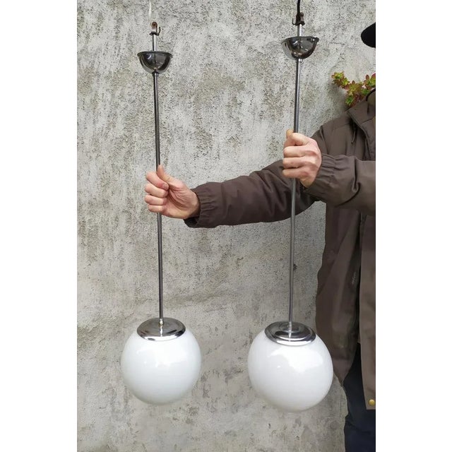 These Two pendant lamps was produced in Italy around the 1930, in the manner of the Bauhaus style. The glass Is white...