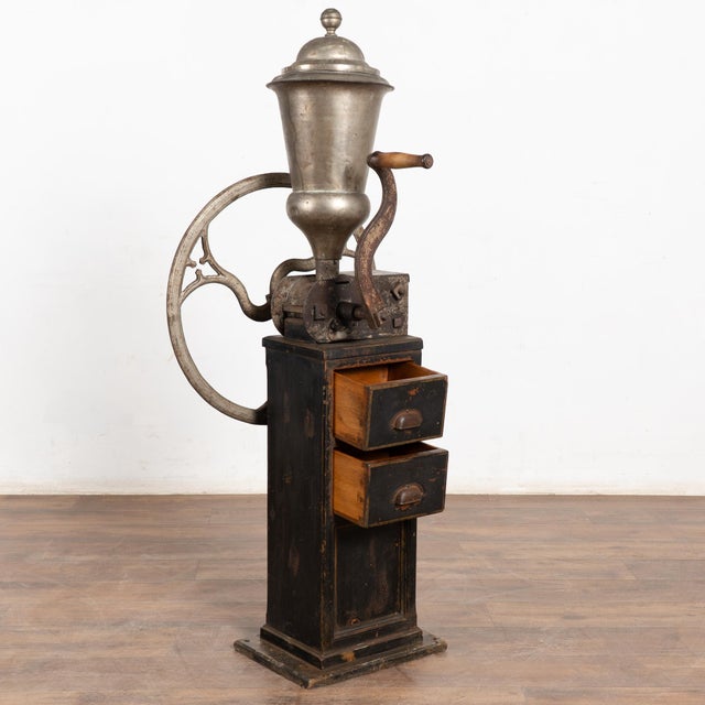 Vintage Danish coffee grinder standing just under 5' tall, featuring a large iron gear mechanism and hand-crank handle....