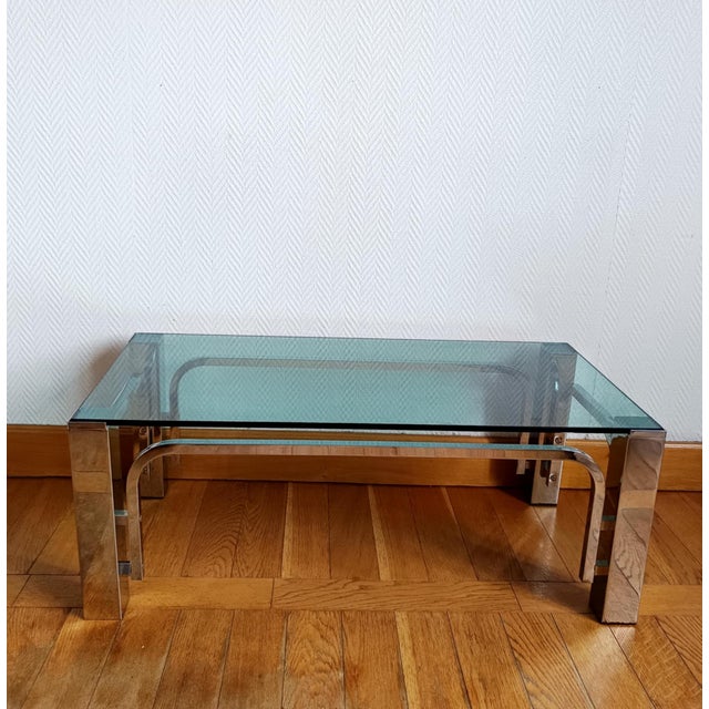 Coffee table with square-section chrome-plated metal legs and a glass top. A pure 1970s design. Beautifully polished...