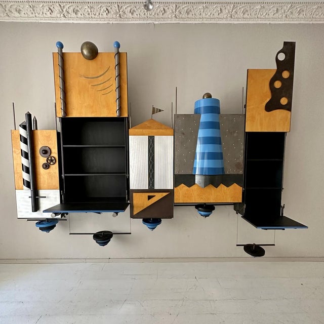 This 1980s Post-Modern One of a Kind Big Wall-Unit was made in metal, lacquered plywood, brass and lacquered plastic. It...