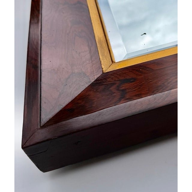 An antique English rosewood wall mirror, circa 1901, retaining the original label of London picture frame maker Ernest...