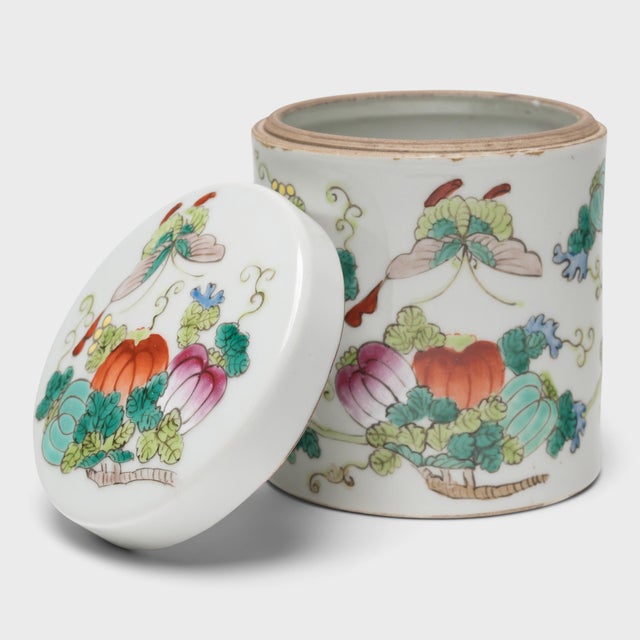 Used to store loose leaf tea, this small porcelain jar is decorated in a style of overglaze enameling known as "famille...