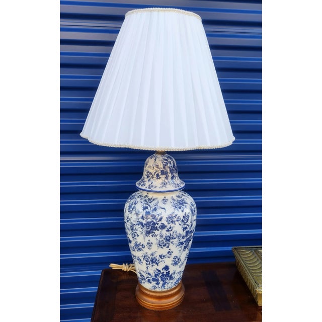 A beautiful blue and white vintage floral ginger jar style table lamp. The lamp features pretty floral design with wood...