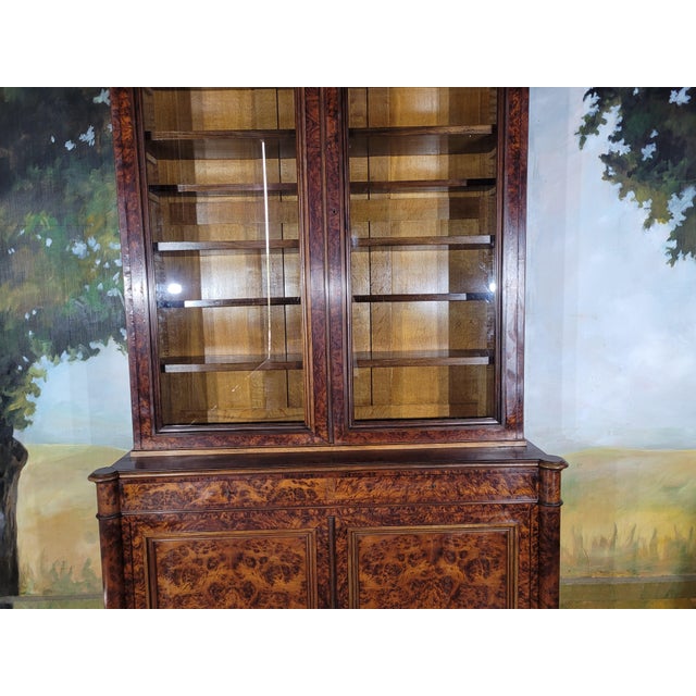 An elegant two-part display cabinet, 19th century. The upper section opens with two glass doors The lower section features...