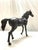 A tall dark bronze horse sculpture with a rich dark brown patina, depicted in a walking pose with forelegs extended in a...