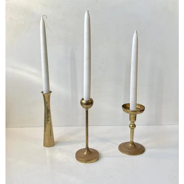 A trio of solid brass candlesticks manufactured in Denmark during the 1970s. The candlesticks are to be fitted with...