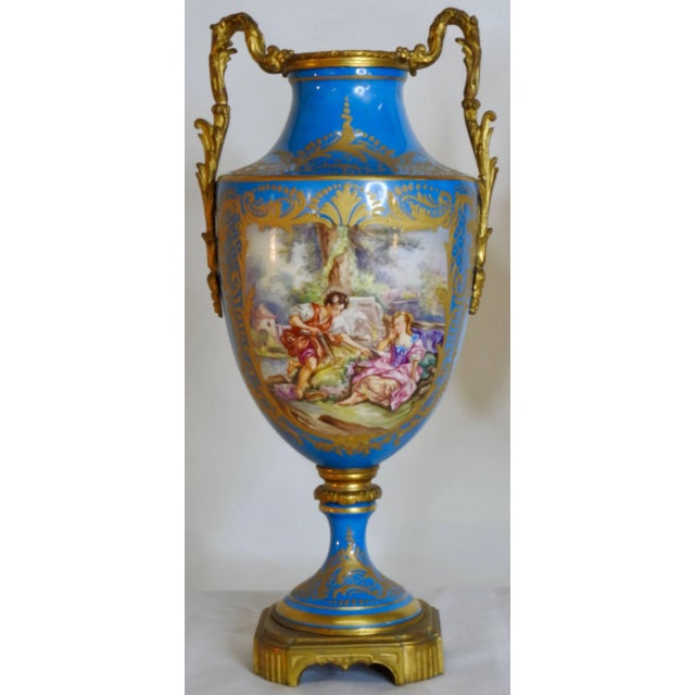 This gorgeous pair of sevre urns start at the bottom with a square bronze gilded base. Rising to the porcelain of the...