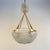 A beautifully sculpted glass shade with layered coquille detailing suspended from elegant braided cords with refined brass...