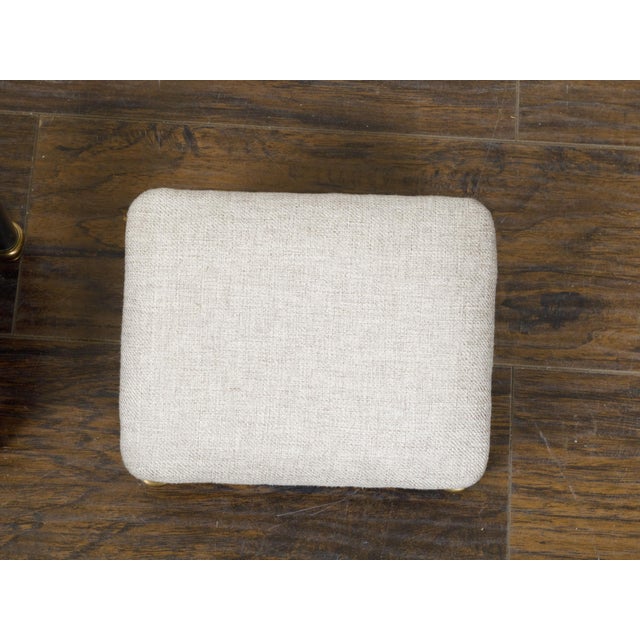 A pair of French steel and bass footstools with custom linen upholstery. This exquisite pair of French footstools combines...