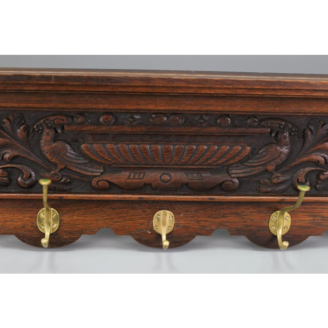 Impressive French hand-carved solid oak wall hanging coat rack from the early 20th century. This beautiful coat rack or...