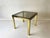A 1970s Italian-style side table in the Hollywood Regency manner. The square frame combines two tones of brass finish:...
