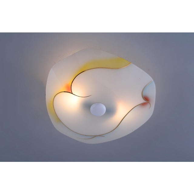 Original 1950s glass ceiling light, with cheerful colours and elegant gold accents. The gilded details nod to the glamour...