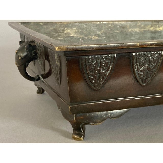 This elegant suiban is made of either bronze with a bronze patina or brass with a bronze patina (the latter gets my vote)....
