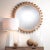 This handcarved wood wall mirror is ornamented with nearly three dozen small wood balls. The sweet yet sophisticated...