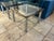 Pair of Italian midcentury modern tables in polished steel with a coppery brass branding and inset glass tops. The tables...