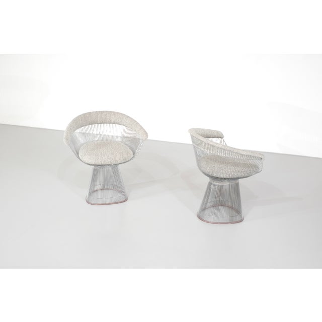 Wire chair upholstered in a white and gray wool-blend fabric, with a steel wire frame. Designed by Warren Platner for...