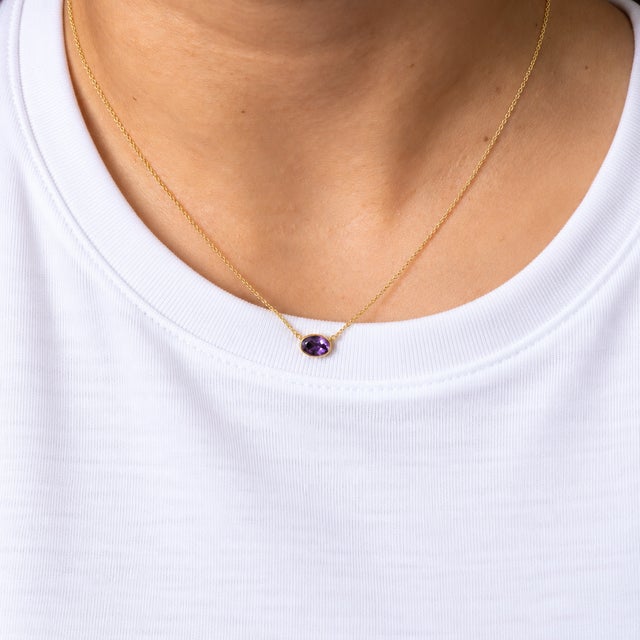 An amethyst oval necklace set in solid 14K yellow gold. Amethyst, the February birthstone, has adorned royalty for...