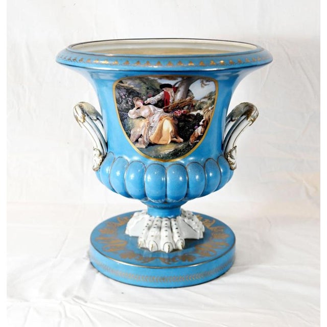 A magnificent pair of French Sèvres-style porcelain urns with a striking sky-blue ground Each urn features a finely...