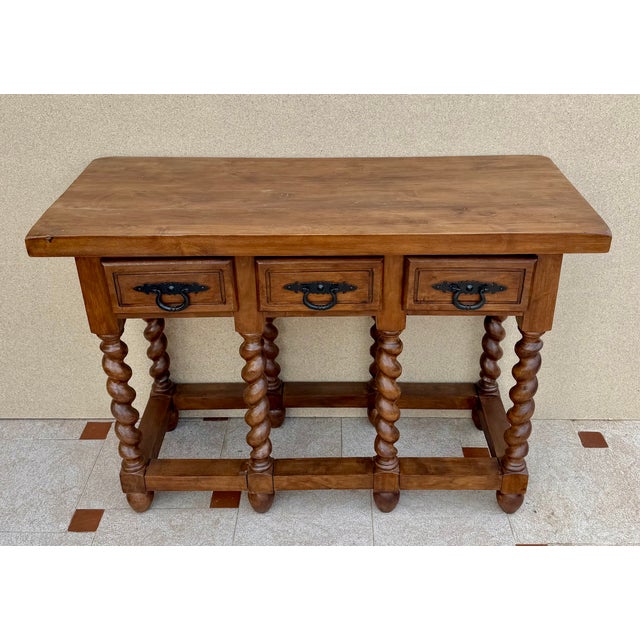 Handsome Spanish console table crafted in solid wood, featuring three drawers with original iron ring pulls, beautifully...
