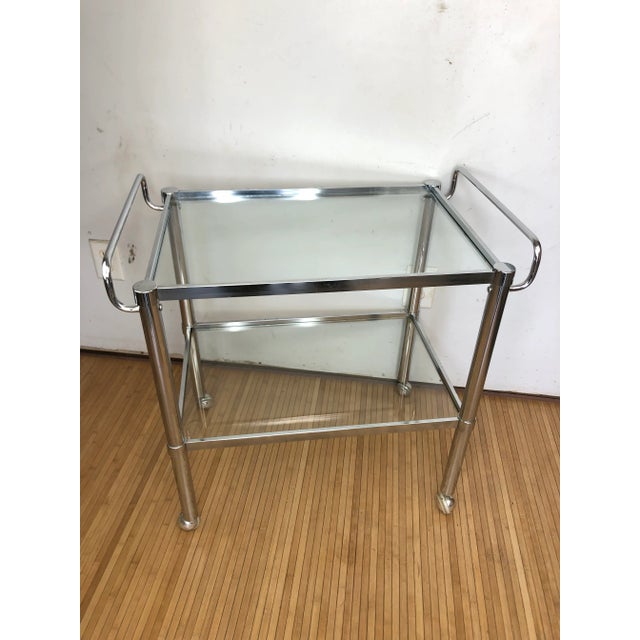 Vintage mid- century chrome and glass two tiered bar cart. Glass are set in place and do not come out. Cart moves freely...