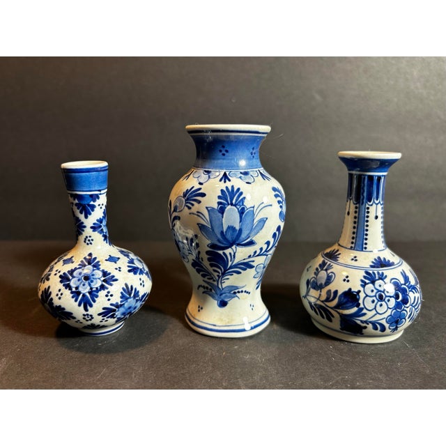 Vintage grouping of three small blue & white delft pottery bud vases. All are hand painted and signed on the bottom. Sizes...