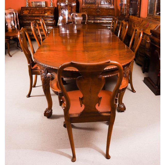 This is a fabulous dining set comprising an antique Queen Anne Revival burr walnut dining table, by the renowned retailer...