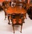 This is a fabulous dining set comprising an antique Queen Anne Revival burr walnut dining table, by the renowned retailer...