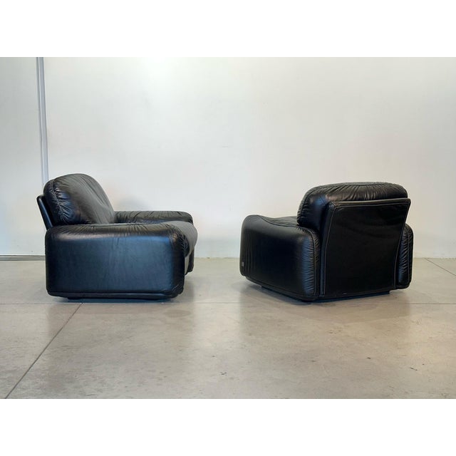 Black leather armchairs, Piumotto model, by Arrigo Arrigoni for Busnelli, 1970s, with branded plastic shell This piece has...
