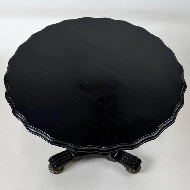 An elegant 19th-century French side table, distinguished by its sophisticated ebonised finish, finely executed brass...
