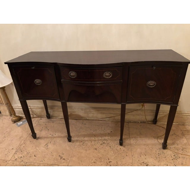 This elegant mahogany sideboard is a timeless piece that combines classic craftsmanship with everyday functionality....