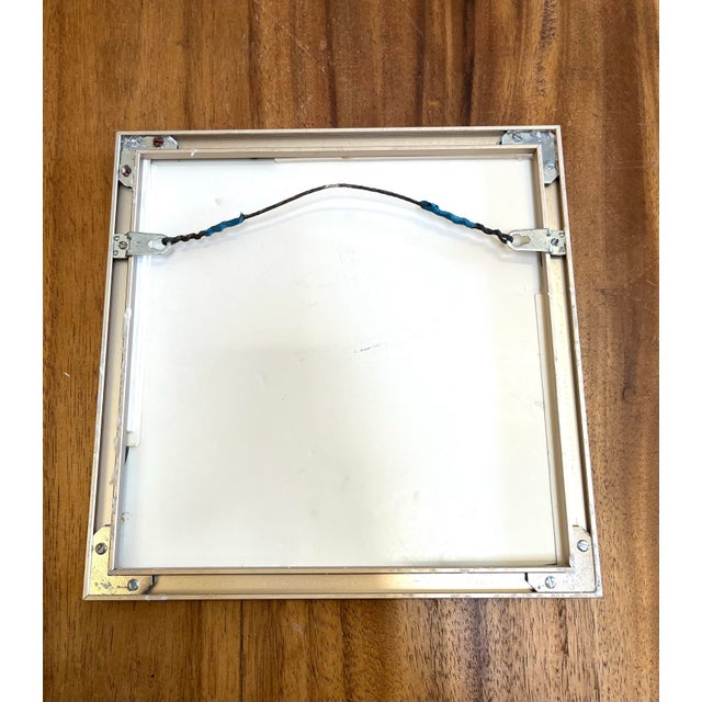 Shell themed framed wall art featuring four distinct sea shell illustrations in a minimalist silver-toned square frame...