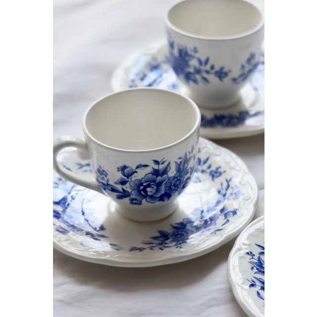 Charming set consisting of four antique white earthenware teacups and saucers. Featuring a deep blue floral design typical...