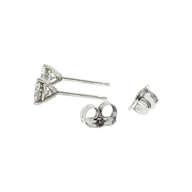 A vintage pair of 14k gold stud earrings featuring brilliant-cut white diamonds. The diamonds have a total carat weight of...