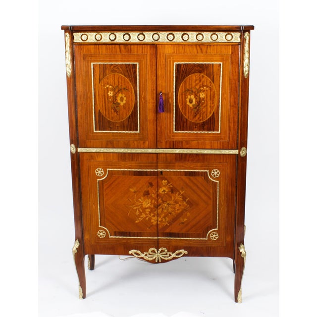 This is a stupendous vintage MIMuble Francais Empire Revival burr walnut and ormolu mounted cocktail cabinet with fitted...