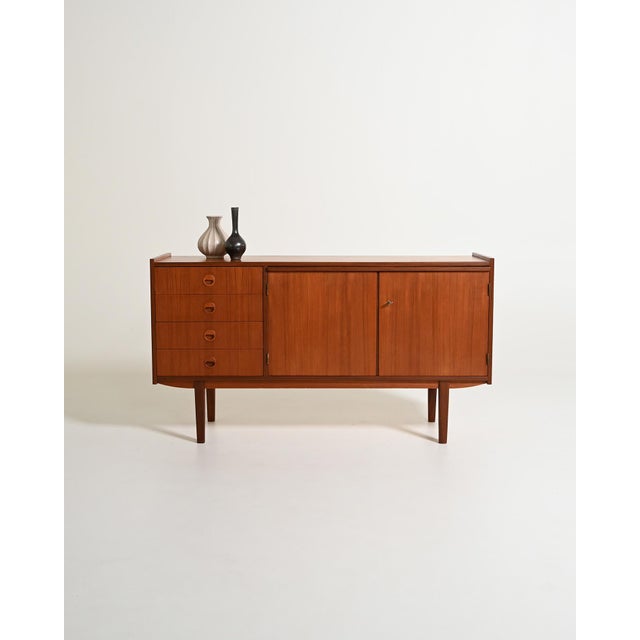 Teak sideboard with four drawers, ample storage, and a pull-out shelf. Scandinavian production from the 1960s. The clean...
