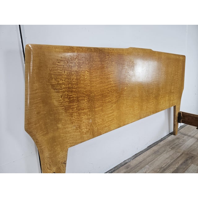 An elegant 1950s vintage double bed, characterized by soft, sinuous lines, rounded shapes, and a refined honey hue that...