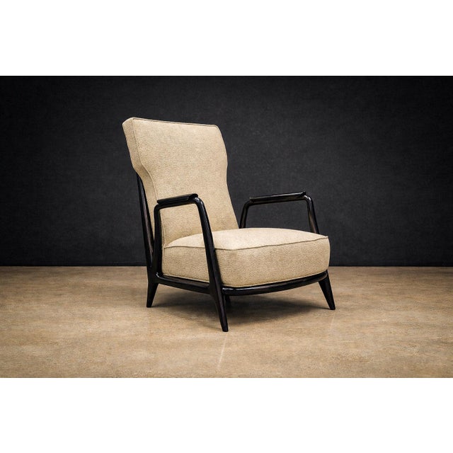 Executed in pau marfim (ivory wood) with an ebony finish, this armchair exemplifies the sculptural refinement...