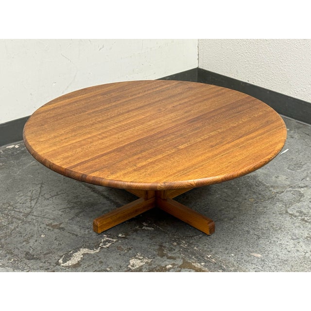 Design Plus Gallery presents a Mid 20th Century Modern Round Wood Coffee Table with Cross Base. This American made table...