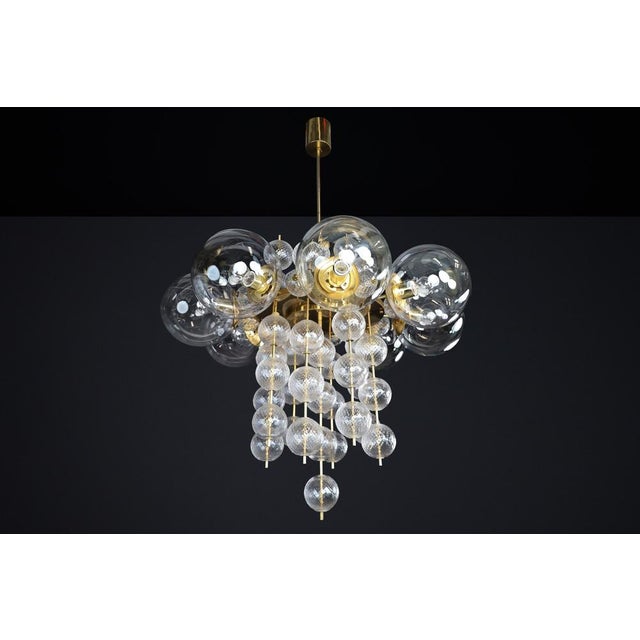 A striking monumental czech chandelier from the 1960s, combining sculptural brass architecture with brilliant clear...