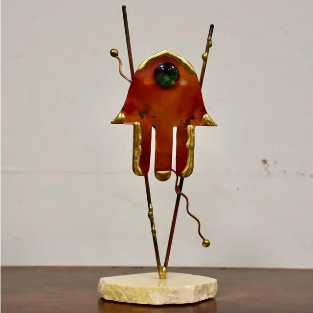 An abstract modern gold colored brass and copper sculpted piece of art signed and dated.