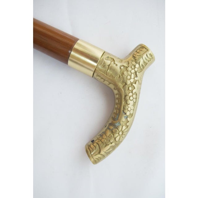 Victorian-style walking cane features an ornate brass Derby handle with embossed floral designs. Unscrew the handle to...