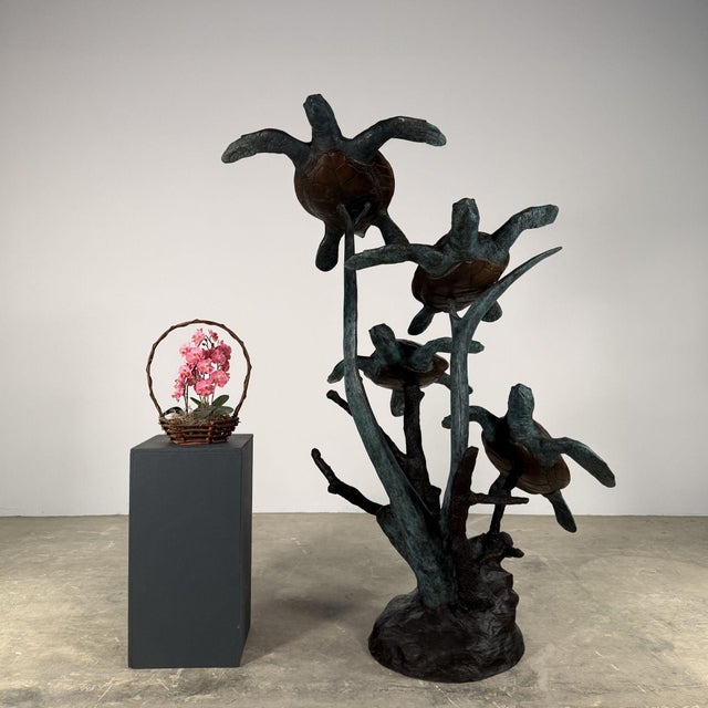 Beautifully hand-cast bronze sculpture featuring four sea turtles swimming upward through a branching coral-like form....