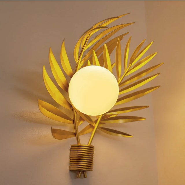 The Palm Sconce brings tropical elegance into any setting with its intricately hand-molded palm leaf silhouette, casting...