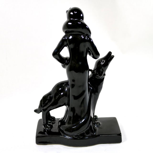Rare Art Deco high gloss black figurine from Seymour Mann. This sculpture depicts an elegant woman walking a dog,...