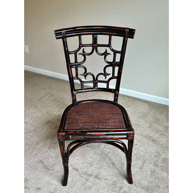 Vintage faux bamboo side chair featuring an elegant Chippendale-inspired fretwork back and woven rattan seat. Finished in...